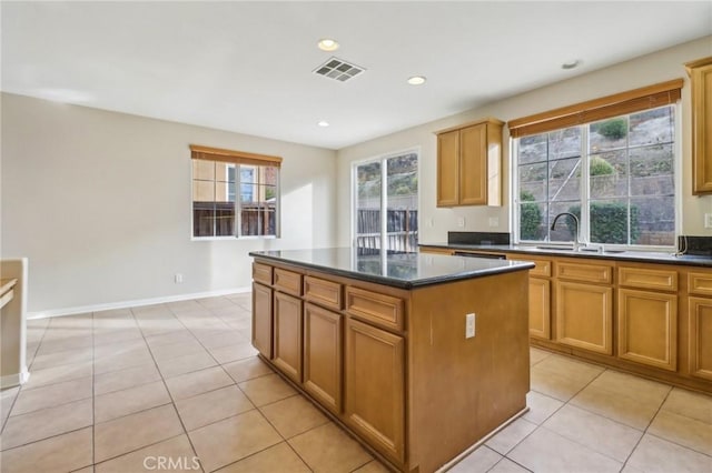 kitchen with light tile patterned flooring, sink, and a center island