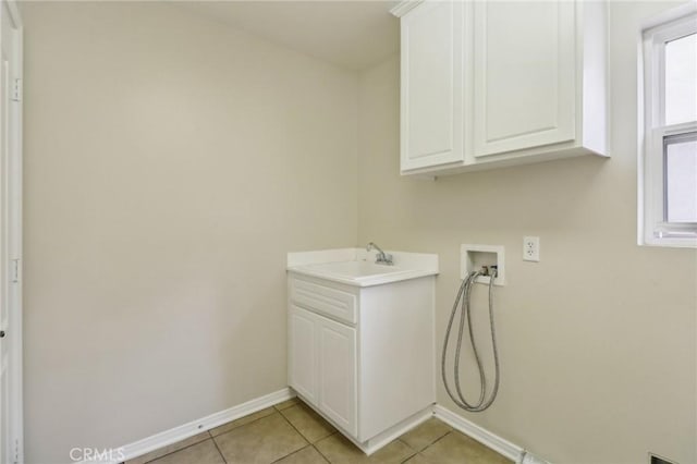 clothes washing area featuring cabinets, sink, hookup for a washing machine, and light tile patterned flooring