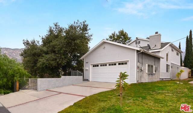 view of front of property with a front yard, a garage, and a mountain view