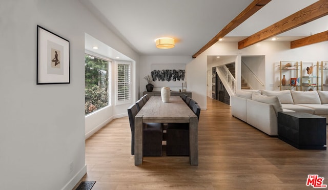 dining space featuring beamed ceiling and hardwood / wood-style floors