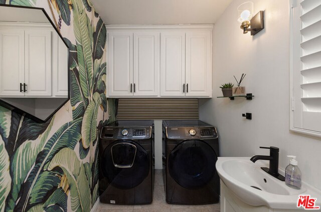 washroom featuring light tile patterned floors, washer and clothes dryer, and sink