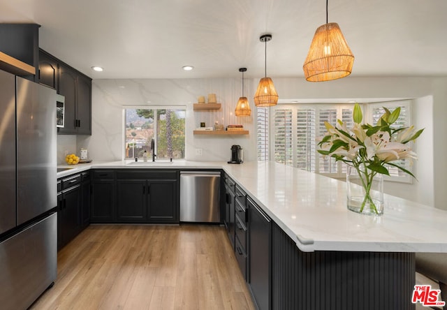 kitchen featuring kitchen peninsula, appliances with stainless steel finishes, sink, and plenty of natural light