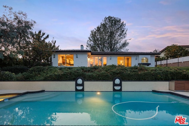 view of pool at dusk