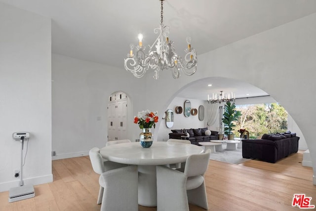 dining space with a notable chandelier and light hardwood / wood-style flooring