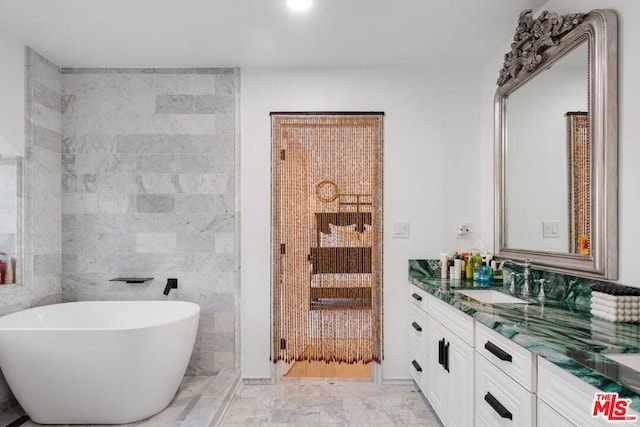 bathroom featuring tile walls, a tub to relax in, and vanity