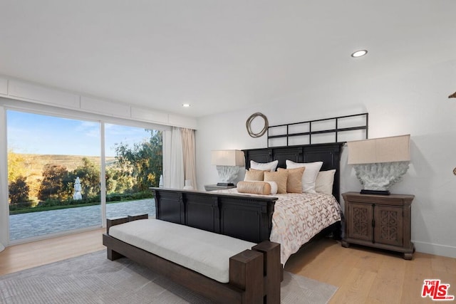 bedroom with access to exterior and light hardwood / wood-style flooring