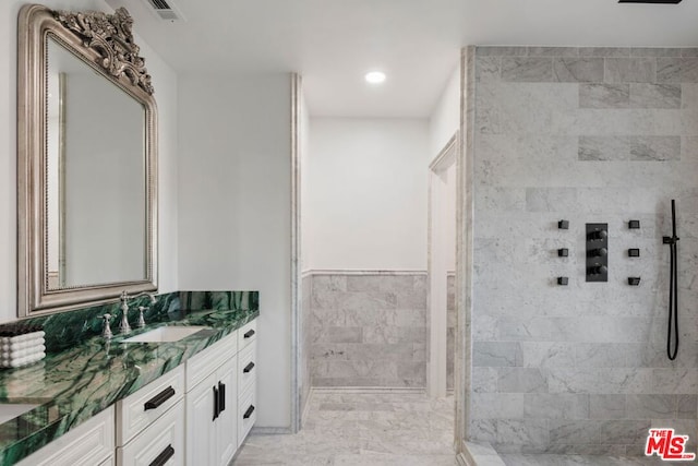 bathroom featuring vanity and tile walls