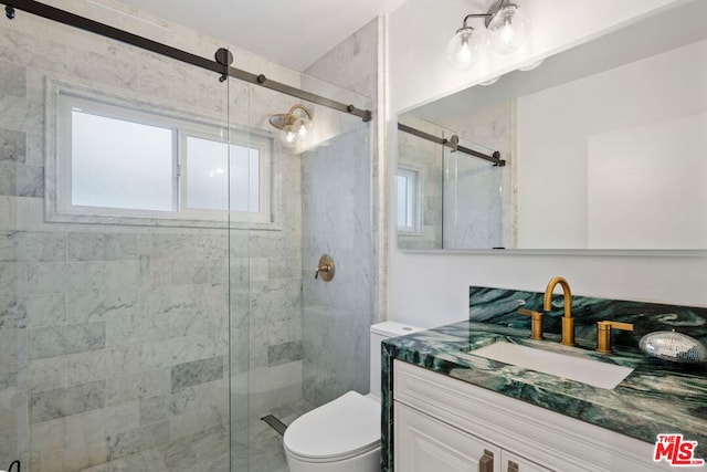 bathroom with a shower with shower door, toilet, and vanity