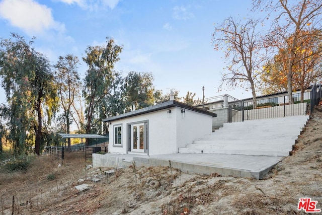 rear view of property featuring french doors and a deck