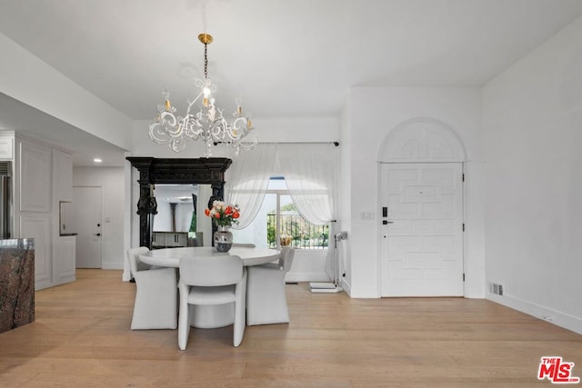 dining space with light wood-type flooring and a chandelier