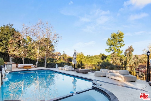 view of pool with a hot tub and a patio