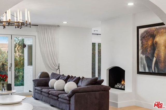 living room with a healthy amount of sunlight, hardwood / wood-style flooring, and a notable chandelier