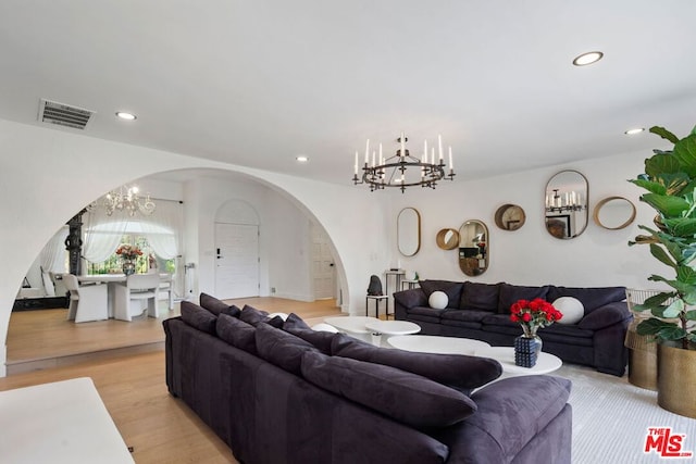 living room featuring light hardwood / wood-style floors and a notable chandelier