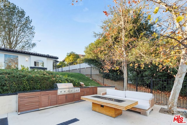 view of patio / terrace with an outdoor fire pit, a grill, and exterior kitchen