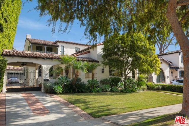 mediterranean / spanish home featuring a front lawn