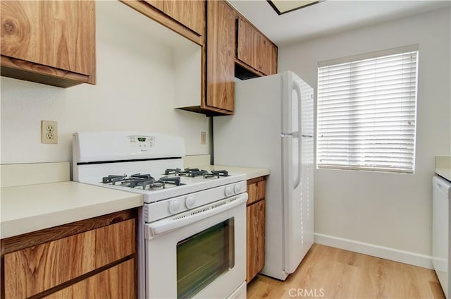 kitchen featuring light wood-type flooring and white appliances