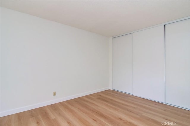 unfurnished bedroom with a closet and light hardwood / wood-style flooring