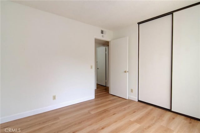 unfurnished bedroom featuring light hardwood / wood-style floors and a closet