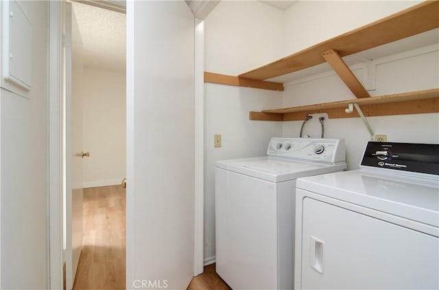 laundry area featuring washer and dryer and light hardwood / wood-style floors