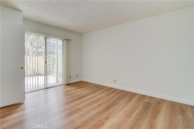 unfurnished room with a textured ceiling and light hardwood / wood-style flooring