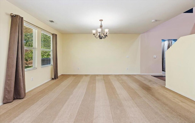 spare room with a chandelier and light colored carpet