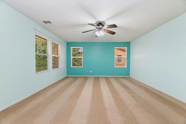 carpeted empty room featuring ceiling fan