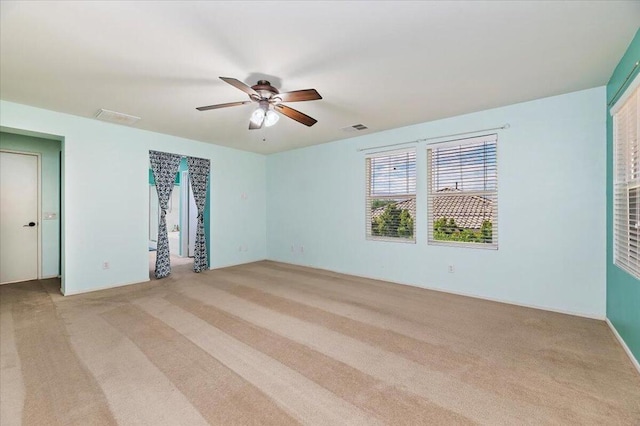 spare room featuring light carpet and ceiling fan