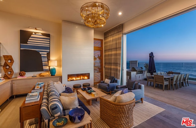 interior space with hardwood / wood-style flooring, a notable chandelier, a water view, and a fireplace