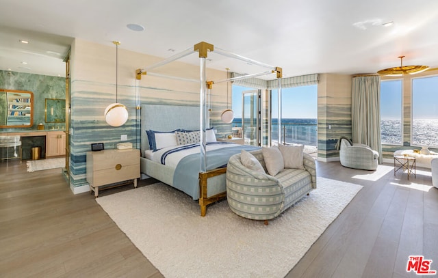 bedroom featuring a water view and hardwood / wood-style floors