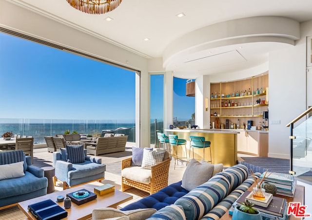 interior space featuring bar area, a water view, and a healthy amount of sunlight