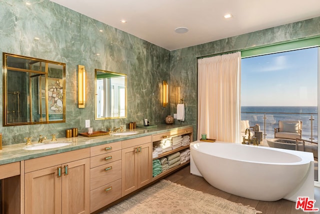 bathroom featuring a washtub, hardwood / wood-style floors, and vanity