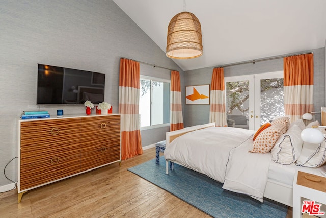 bedroom featuring hardwood / wood-style flooring, french doors, and vaulted ceiling