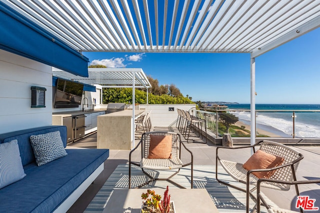 view of patio / terrace with a beach view, sink, a water view, an outdoor living space, and a pergola