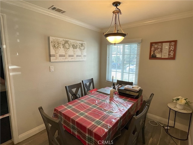 dining area with ornamental molding and dark hardwood / wood-style flooring