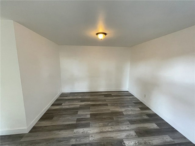 unfurnished room with dark hardwood / wood-style flooring