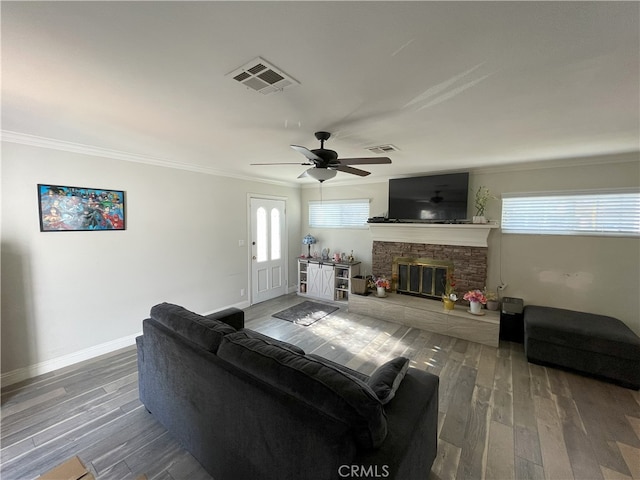 living room with a fireplace, ceiling fan, ornamental molding, and hardwood / wood-style floors