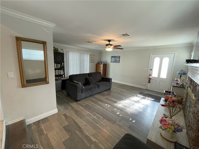 living room featuring dark hardwood / wood-style floors, crown molding, and a fireplace