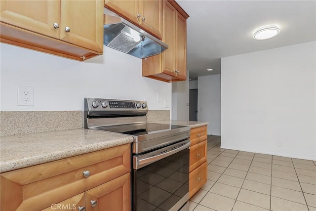 kitchen featuring light tile patterned floors, stainless steel range with electric cooktop, and light stone counters