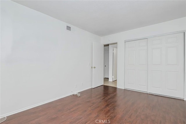 unfurnished bedroom with a closet and wood-type flooring