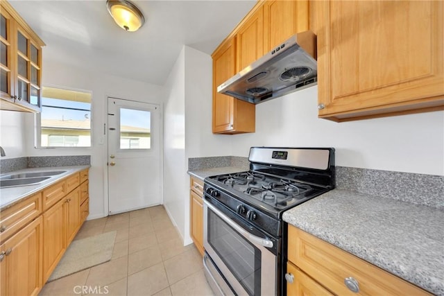 kitchen featuring light tile patterned flooring, extractor fan, stainless steel range with gas cooktop, and sink