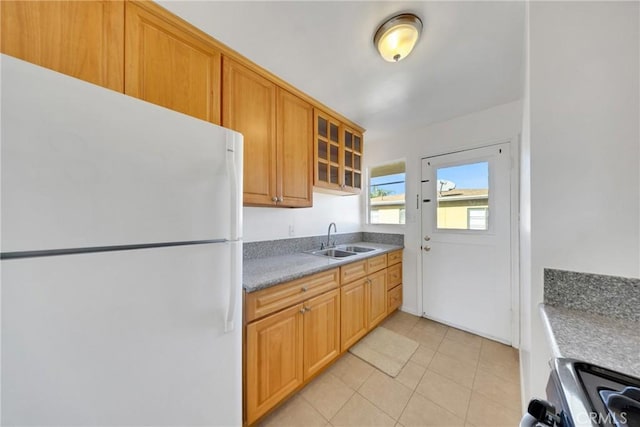 kitchen featuring light tile patterned floors, sink, white fridge, and range