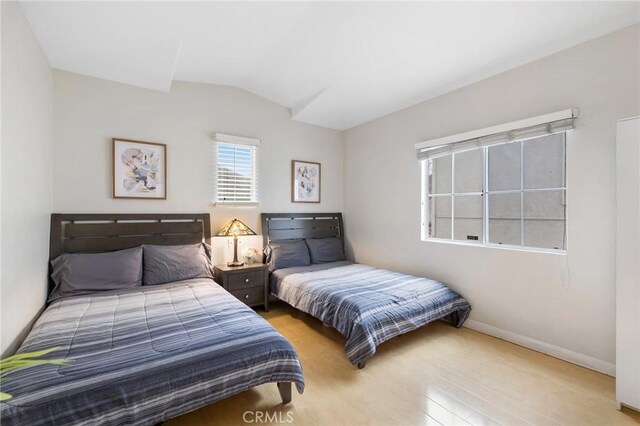 bedroom featuring lofted ceiling and light wood-type flooring