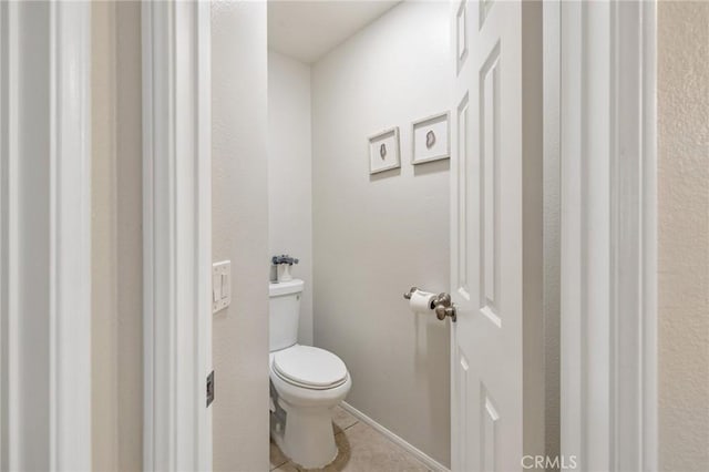 bathroom with toilet and tile patterned flooring