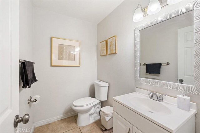 bathroom featuring toilet, vanity, and tile patterned flooring