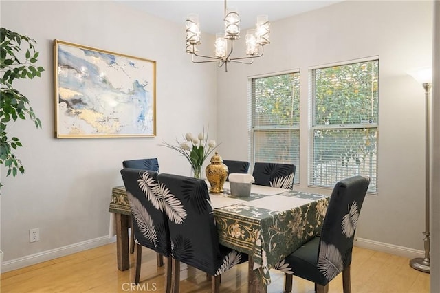 dining area featuring light hardwood / wood-style floors and an inviting chandelier