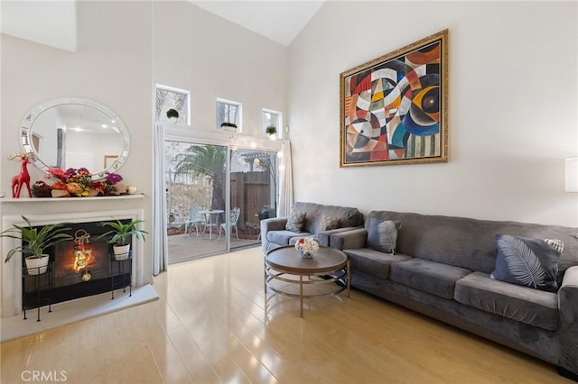 living room with light wood-type flooring and high vaulted ceiling