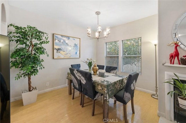 dining space featuring light hardwood / wood-style floors and a notable chandelier