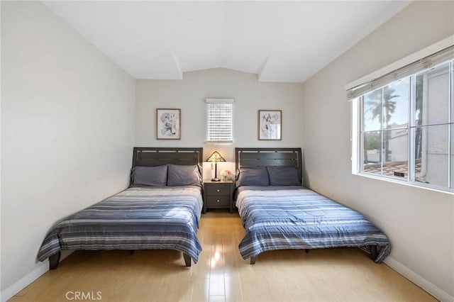 bedroom with wood-type flooring and vaulted ceiling