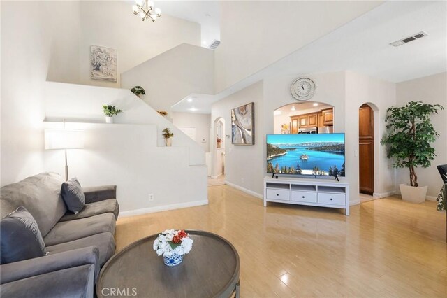 living room with a notable chandelier and light wood-type flooring