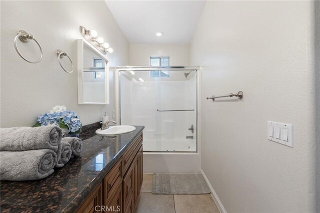 bathroom featuring combined bath / shower with glass door, tile patterned flooring, and vanity